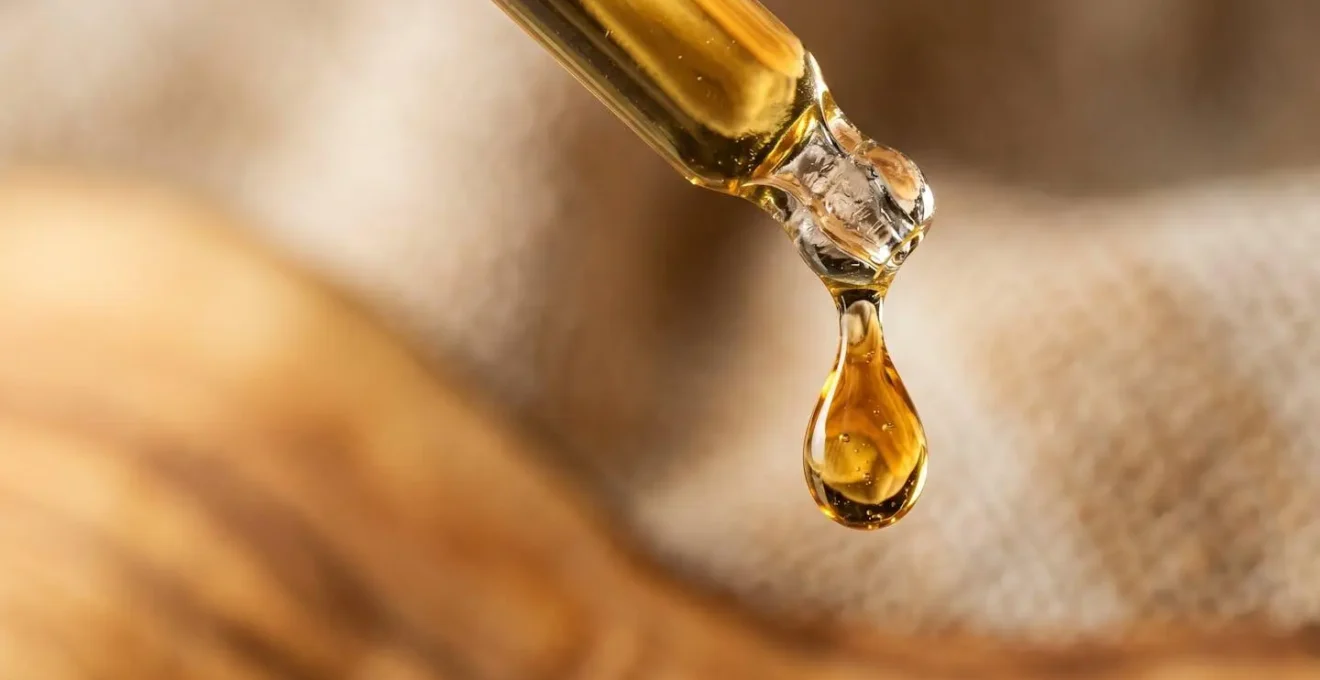 Gros plan d'une pipette d'huile de CBD avec gouttes précises pour dosage